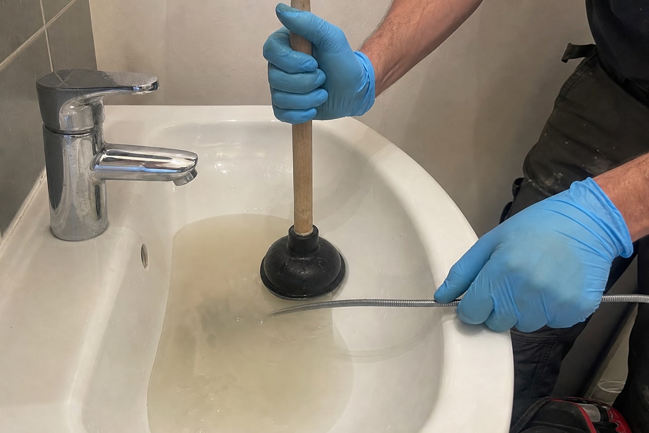 main gantée utilise ventouse débouchage lavabo