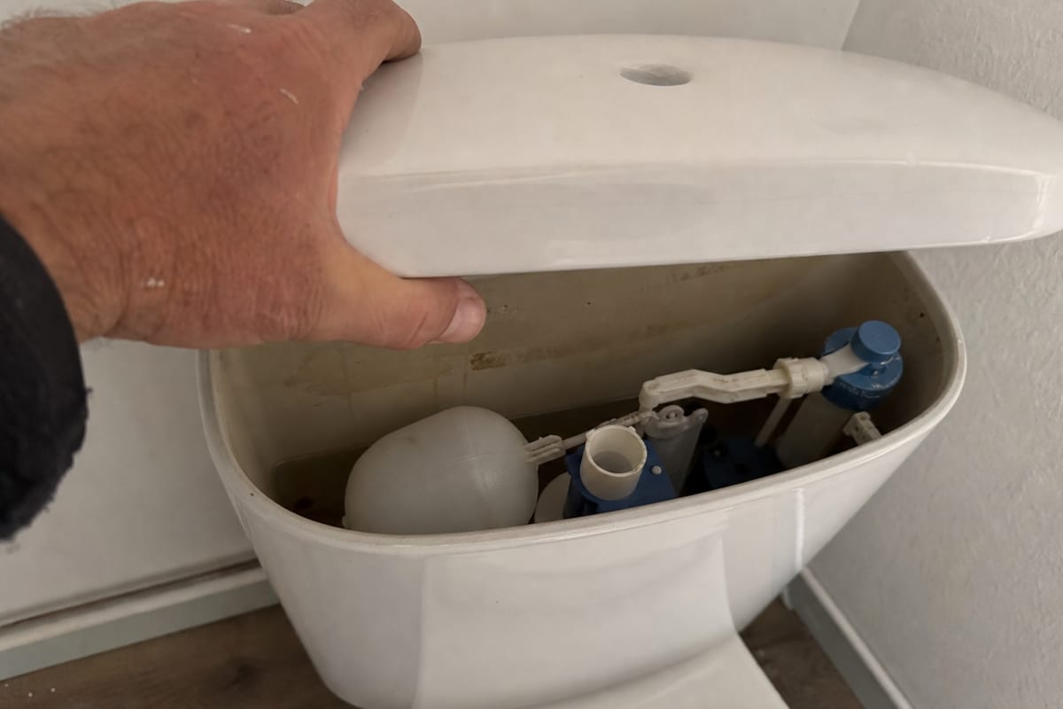 main ouvre réservoir WC accès mécanisme chasse
